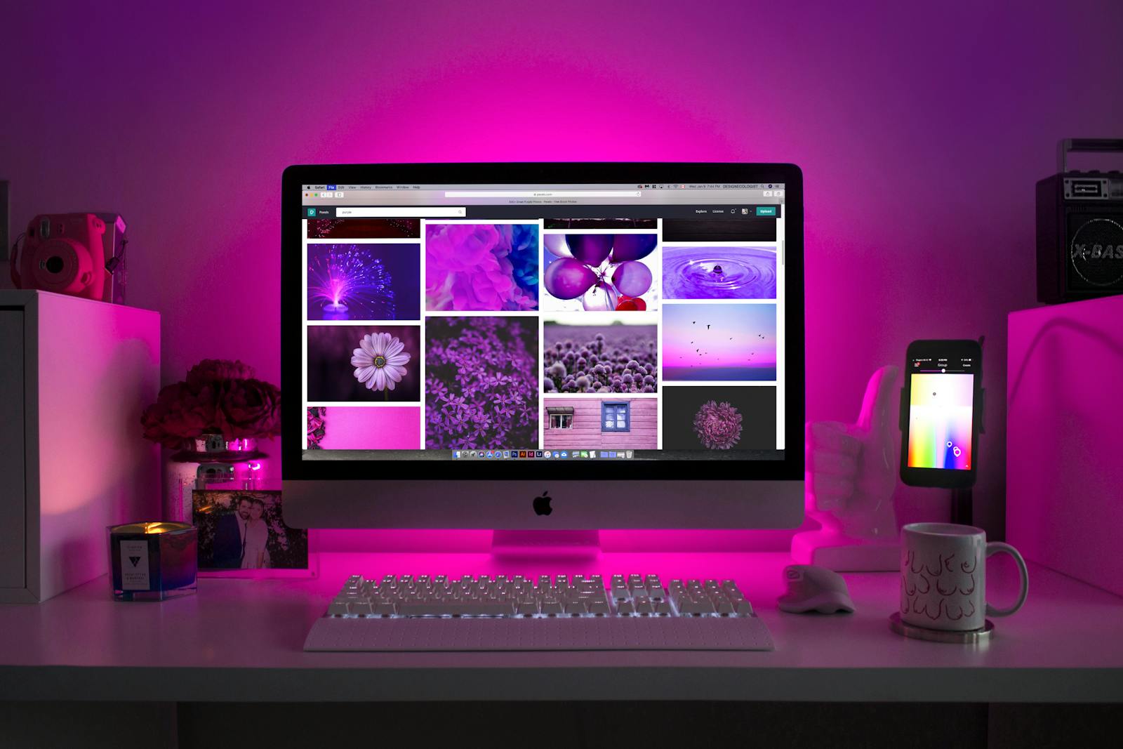 Modern desk setup with neon lighting and a desktop computer displaying colorful images. wix website builder