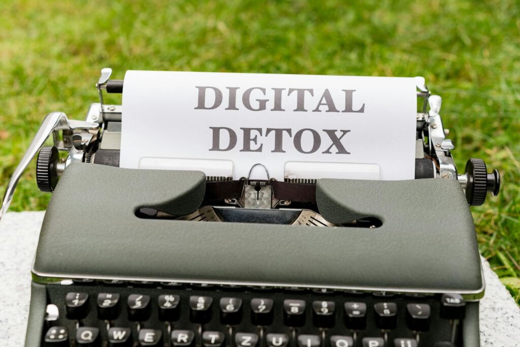 A classic typewriter displaying the words 'Digital Detox' outdoors, symbolizing a break from technology.