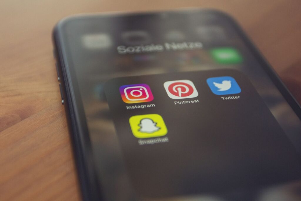 7 Social Media Apps Your Business Needs to Stop Playing Hide and Seek 1 Smartphone displaying popular social media apps like Instagram, Pinterest, Twitter, and Snapchat.